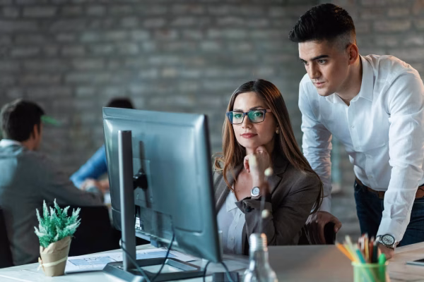 two-young-entrepreneurs-working-computer-reading-email-office_637285-1065